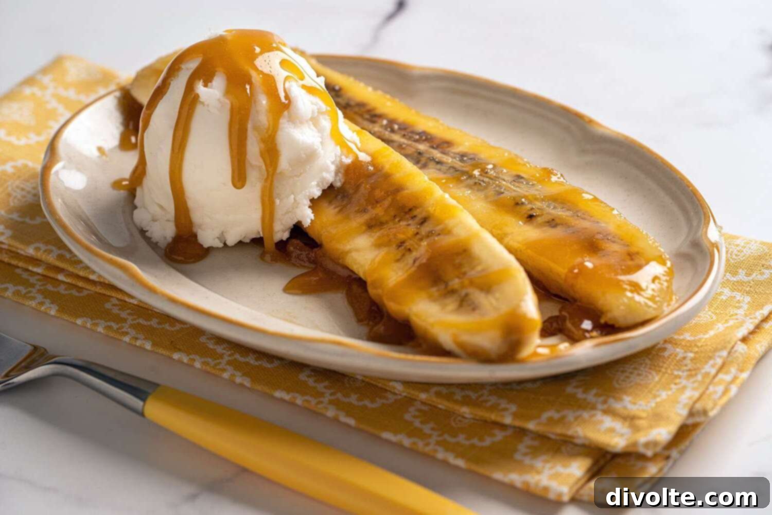 A plate of Bananas Foster with vanilla ice cream, topped with cinnamon and caramel sauce.