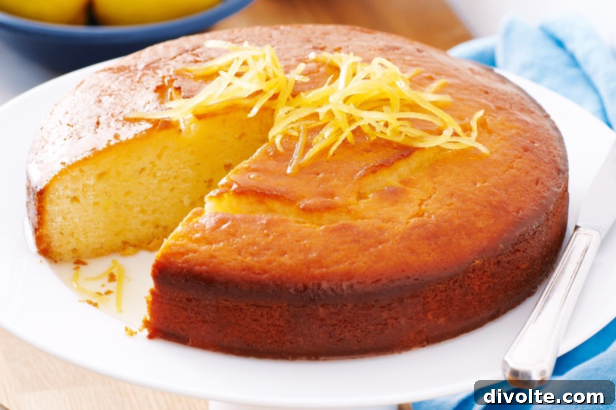 Freshly baked lemon yogurt cake, garnished with a sprinkle of powdered sugar and lemon zest.