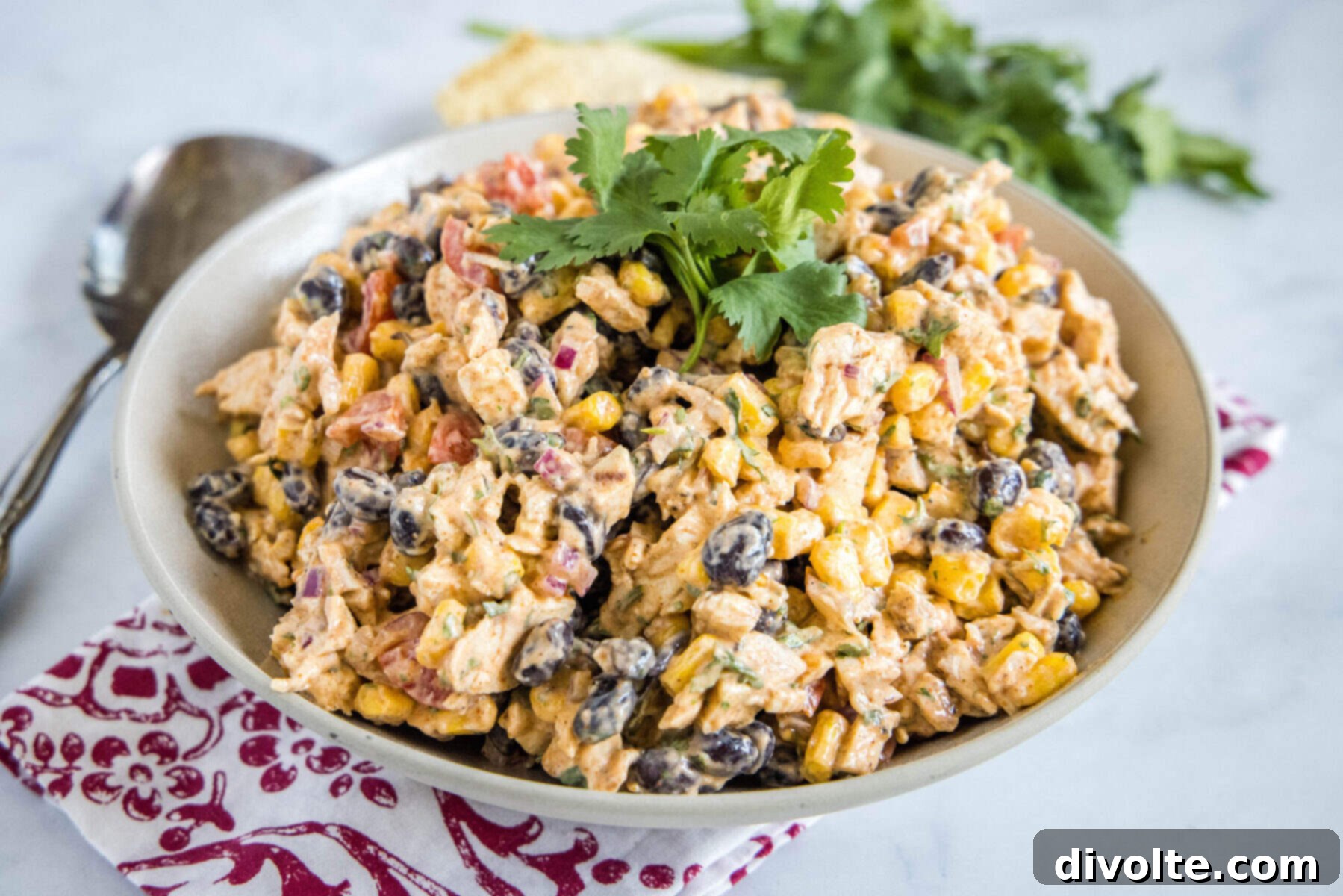 southwest-chicken-salad-recipe - A vibrant and fresh salad with grilled chicken, corn, black beans, avocado, and cherry tomatoes, drizzled with ranch dressing.