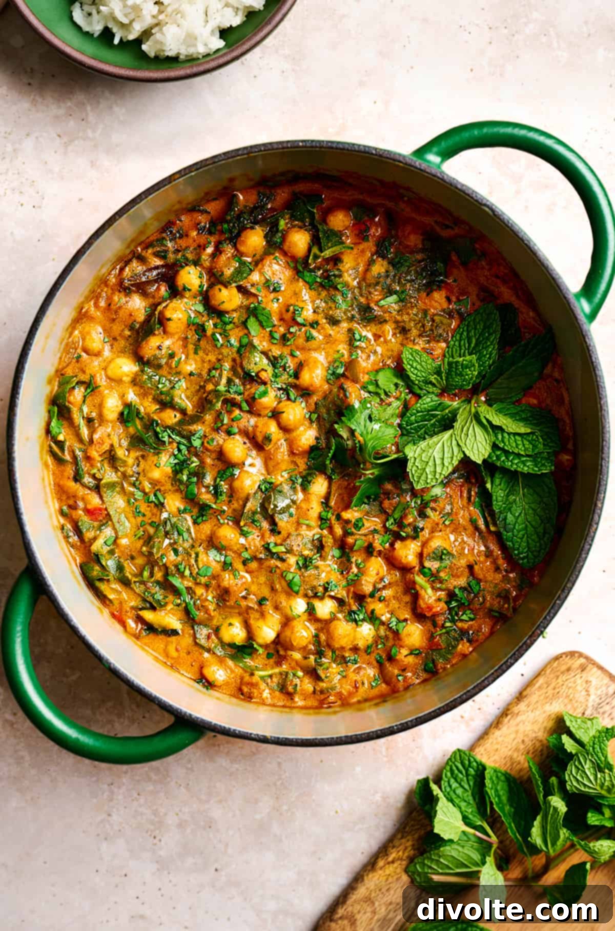 Delicious and creamy chickpea curry recipe in a bowl, garnished with fresh cilantro, served with rice.