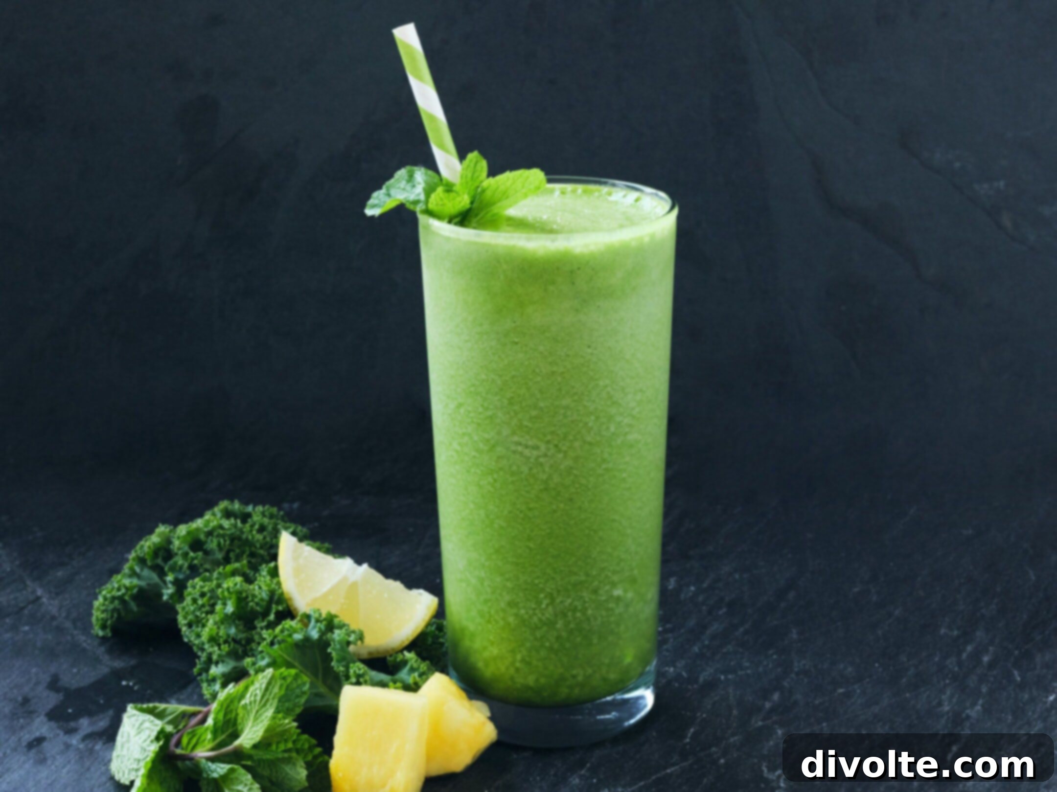 Green smoothie in a glass jar with kale and spinach in the background. A healthy and vibrant drink.