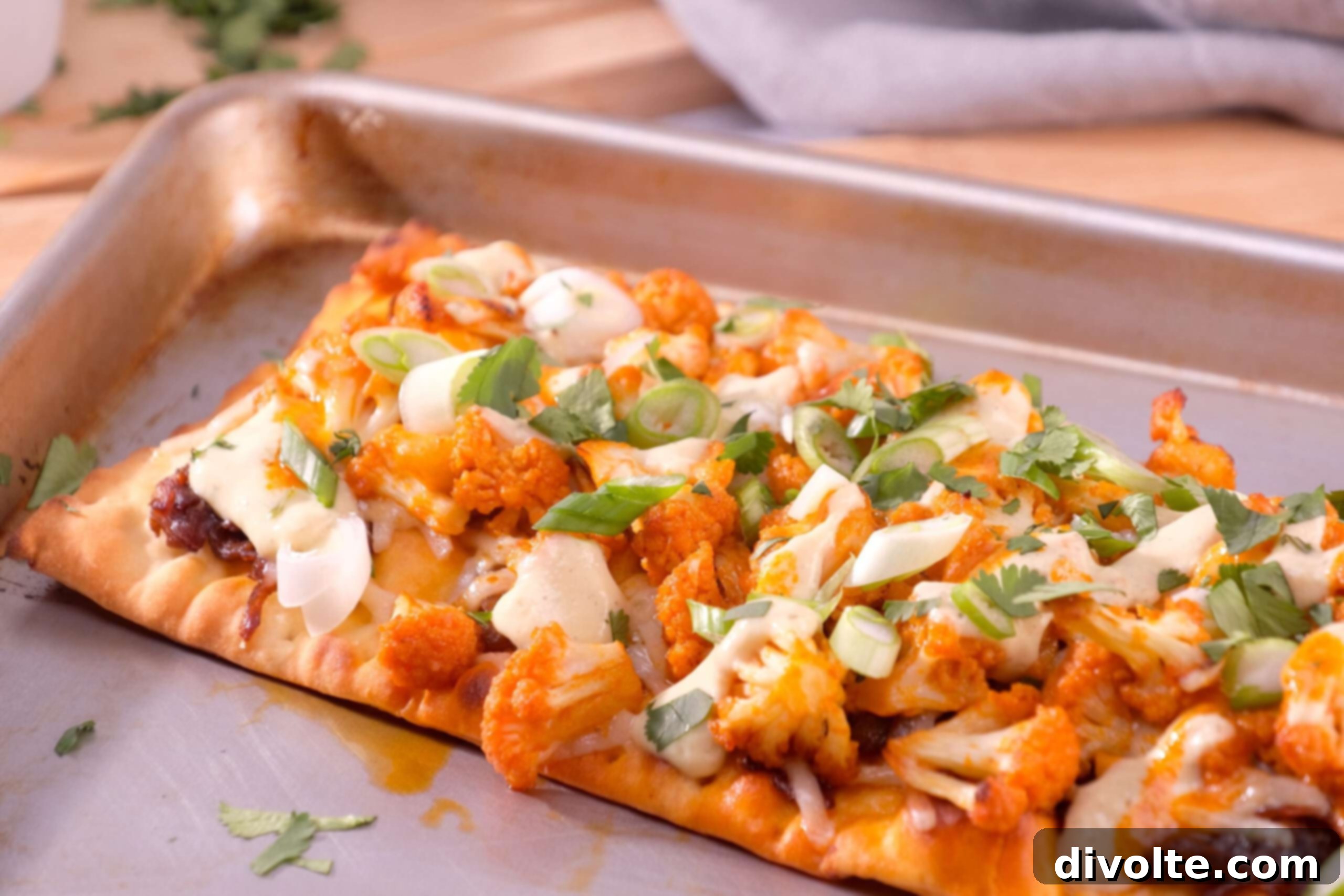 Delicious Buffalo Cauliflower Pizza topped with melted mozzarella and a ranch drizzle, ready to serve.