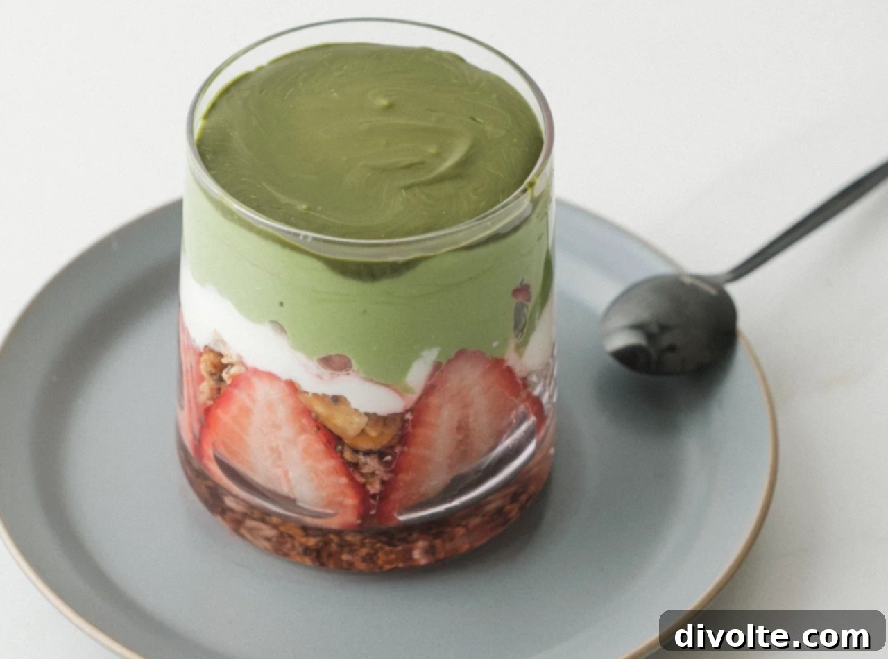 Matcha Parfait Perfection 2 Vibrant green matcha parfait layered with creamy Greek yogurt, crunchy granola, and fresh mixed berries in a glass