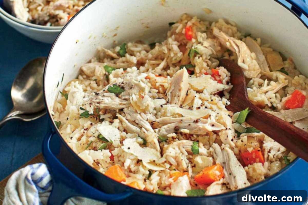 A steaming bowl of traditional Southern Chicken Bog, featuring tender chicken pieces, sliced smoked sausage, and fluffy rice infused with savory broth, garnished with fresh herbs. This comforting one-pot meal is perfect for family dinners.