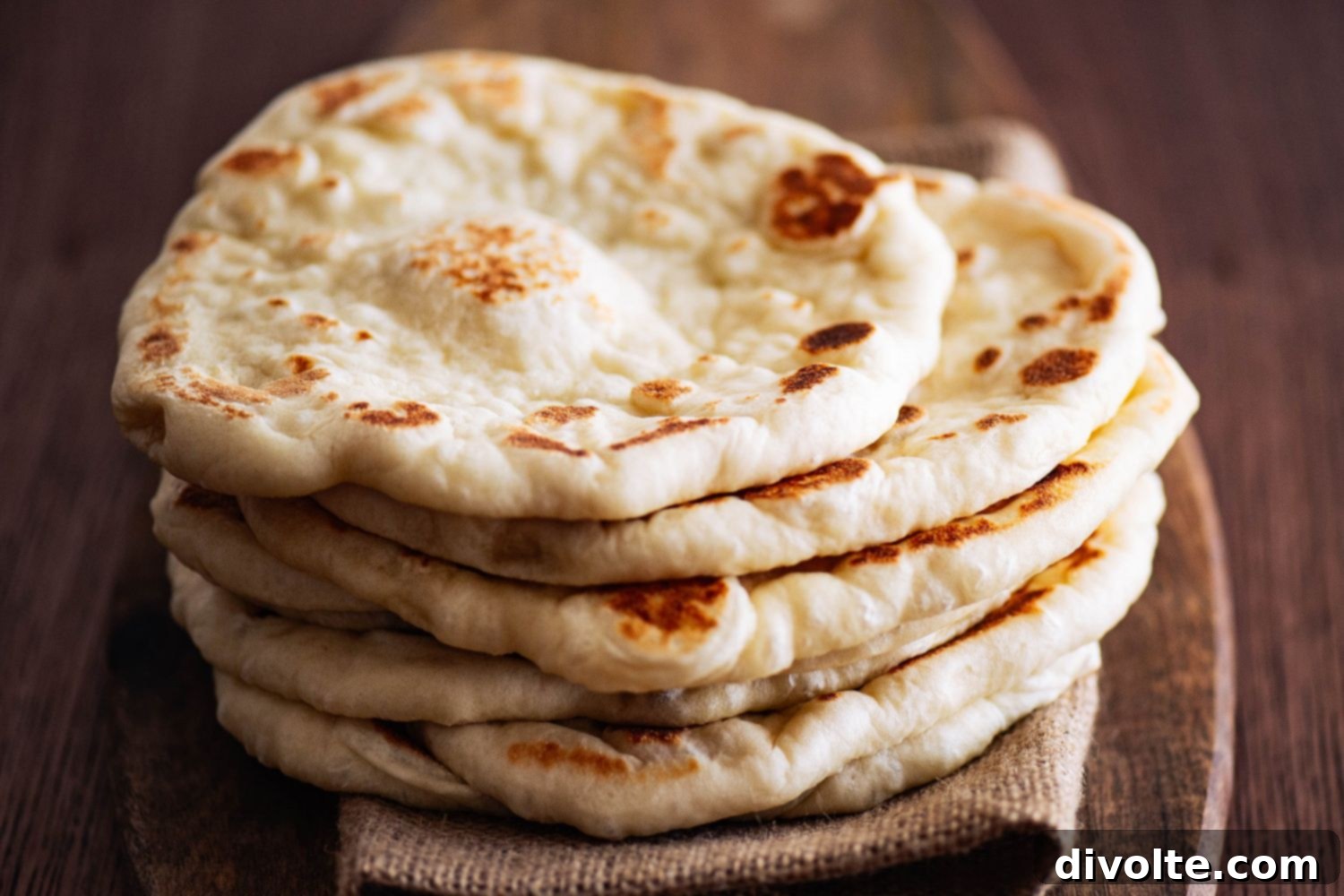 Freshly baked homemade Indian naan bread with golden brown spots, ready to be served